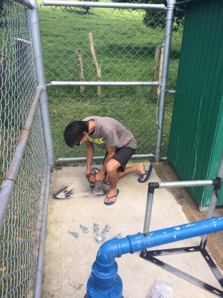 Worker drilling into concrete pad