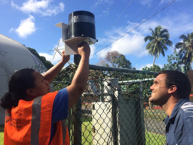 Worker adjusting rain gauge bucket 