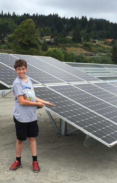 Boy next to solar panels